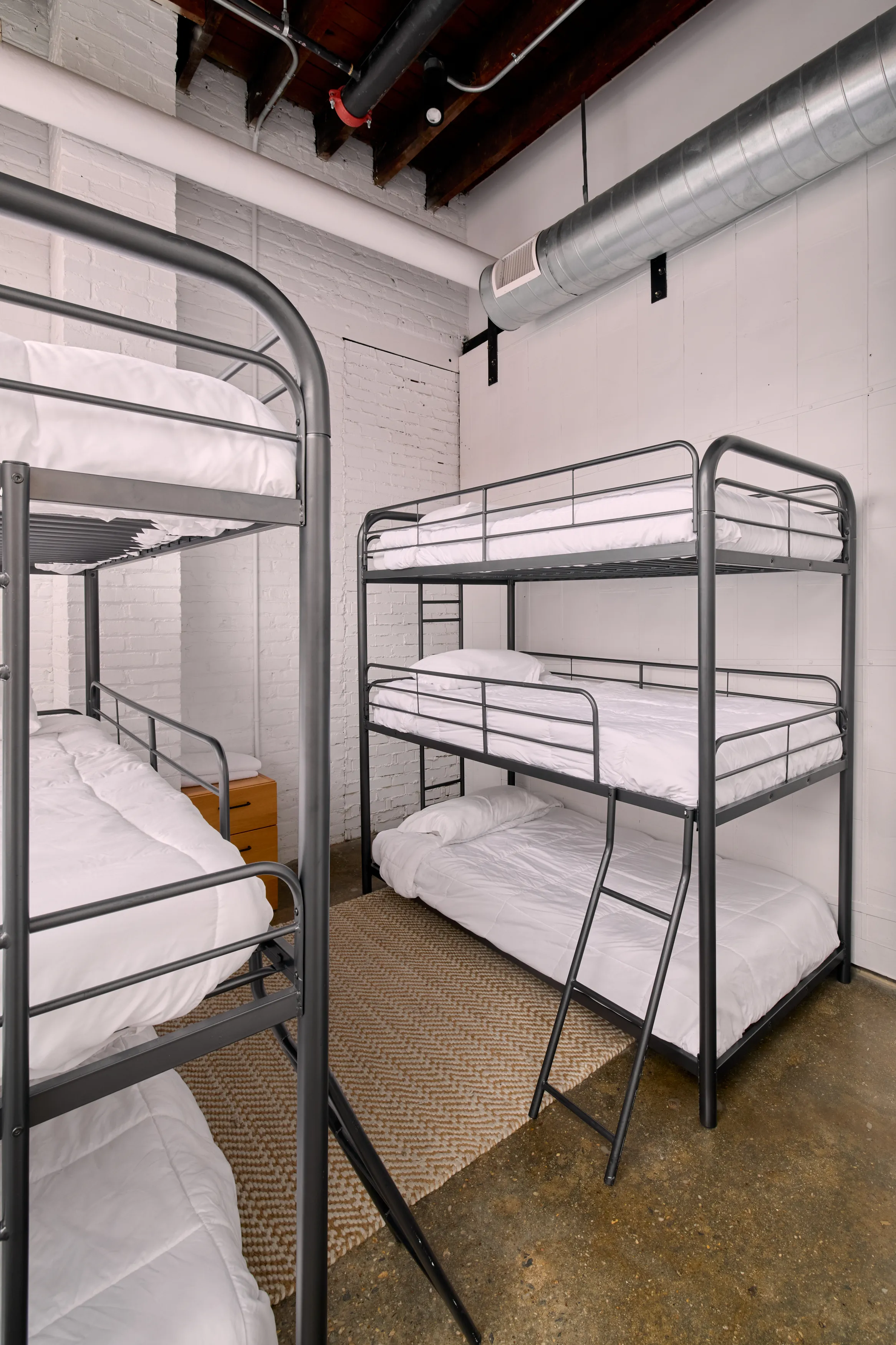 A bedroom with two separate three level bunk beds on each wall